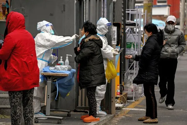 Residents undergo swab testing at a residential area under lockdown due to Covid-19 coronavirus restrictions in Beijing on November 29, 2022. (Photo by Noel Celis/AFP Photo)