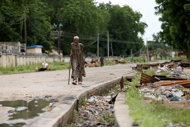An elderly man walks along a nearly empty street, opposite the Nigeria Air Force hospital in Bama, Borno, Nigeria, August 31, 2016. (Photo by Afolabi Sotunde/Reuters)