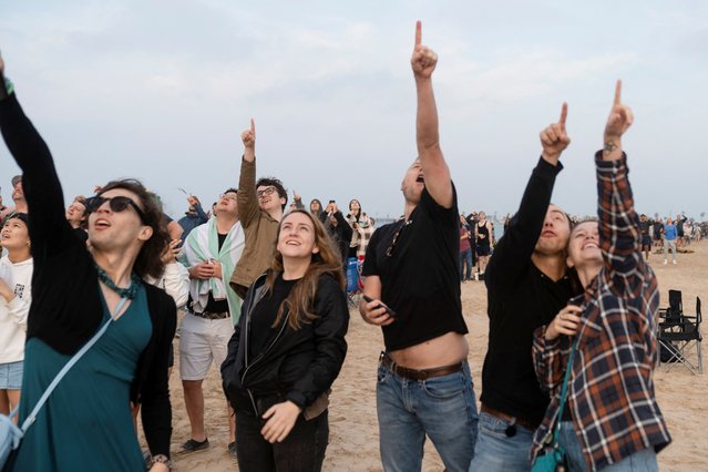 People react as SpaceX's next-generation Starship spacecraft atop its powerful Super Heavy rocket lifts off from the company's Boca Chica launchpad, as seen from South Padre Island, near Brownsville, Texas, on March 14, 2024. (Photo by Cheney Orr/Reuters)
