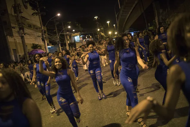 In this January 22, 2018 photo, members of the Paraiso do Tuiuti samba school rehears their dances and songs, which make reference to Brazil's history with slavery, in the streets of Rio de Janeiro, Brazil. The samba school notes that Brazil is one of the world's most unequal countries in terms of income distribution, and that its top politicians and businessmen are predominantly white while more than 50 percent of citizens identify as black or mixed race. (Photo by Leo Correa/AP Photo)