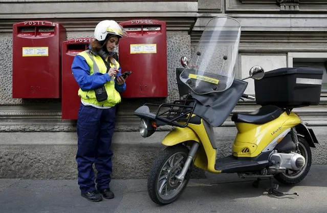 A postwoman use her device in front of headquater of Poste Italiane downtown Milan, Italy, October 22, 2015. Italy is set to raise up to 3.4 billion euros ($3.8 billion) from a stock market listing of state-owned post office operator Poste Italiane, sources close to the matter said on Thursday. (Photo by Stefano Rellandini/Reuters)