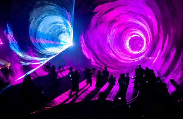 Tourists watch a laser show at Wuhan Jiufeng Forest Zoo on July 19, 2025 in Wuhan, Hubei Province of China. Wuhan Jiufeng Forest Zoo launched a night tour for tourists during summer vacation. (Photo by Zhang Chang/China News Service/VCG via Getty Images)