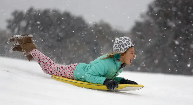 Finley Bork, 7, uses a boogie board, typically used on the beach, for sledding down a hill on a golf course at the Isle of Palms, S.C., Wednesday, January 3, 2018.  A brutal winter storm smacked the coastal Southeast with a rare blast of snow and ice Wednesday, hitting parts of Florida, Georgia and South Carolina with their heaviest snowfall in nearly three decades. (Photo by Mic Smith/AP Photo)