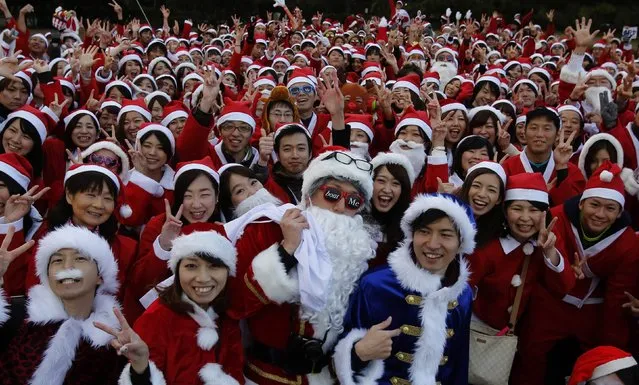 People dressed in Santa costumes pose for pictures during the Tokyo Santa Run at a park in Tokyo December 6, 2014. (Photo by Yuya Shino/Reuters)