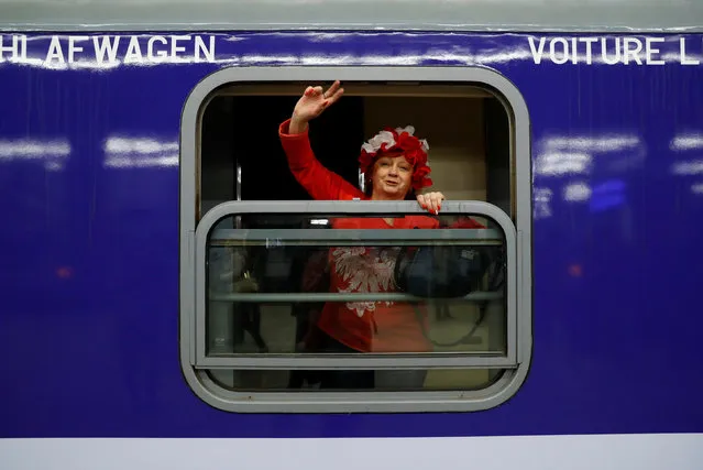 A Polish right-wing activist waves on board a train bound for Budapest, to join the pro-Orban march to be held on the anniversary of the 1848 Hungarian Revolution, at the central train station in Warsaw, Poland March 13, 2018. (Photo by Kacper Pempel/Reuters)