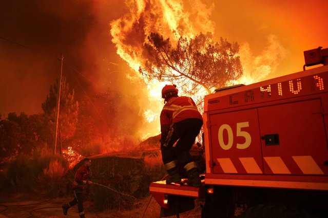A firefighter helps to extinguish a wildfire approaching Benvende, in Trancoso, Portugal, on August 14, 2025. (Photo by Pedro Nunes/Reuters)