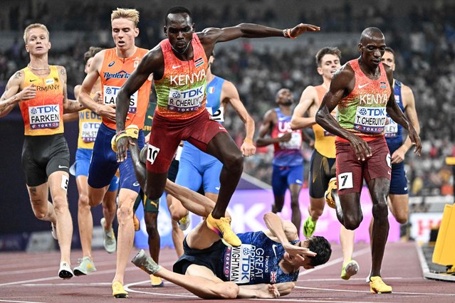Kenya's Reynold Cheruiyot (centre L) and Britain's athlete Jake Wightman fall after crossing the finish line in the men's 1500m final during the World Athletics Championships in Tokyo on September 17, 2025. (Photo by Jewel Samad/AFP Photo)