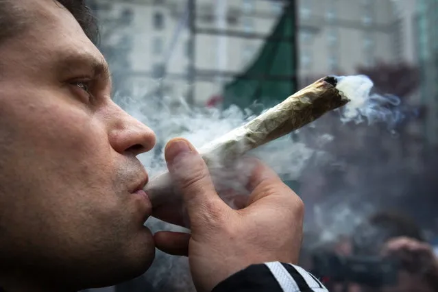 A man smokes marijuana at the Vancouver Art Gallery during the annual 4/20 day, which promotes the use of marijuana, in Vancouver, British Columbia April 20, 2013. (Photo by Ben Nelms/Reuters)