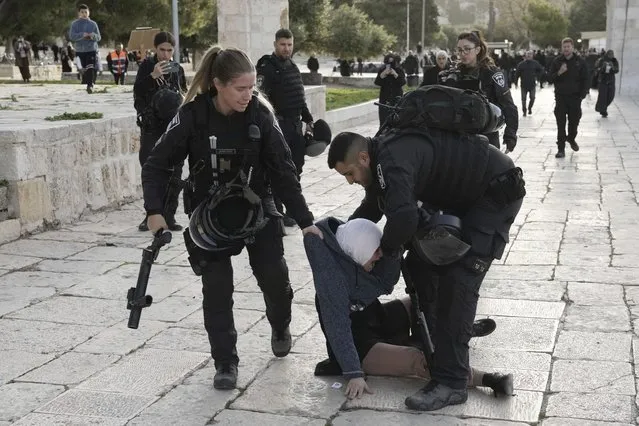 Israeli police arrest a Palestinian woman at the Al-Aqsa Mosque compound following a raid at the site in the Old City of Jerusalem during the Muslim holy month of Ramadan, Wednesday, April 5, 2023. Palestinian media reported police attacked Palestinian worshippers, raising fears of wider tension as Islamic and Jewish holidays overlap. (Photo by Mahmoud Illean/AP Photo)