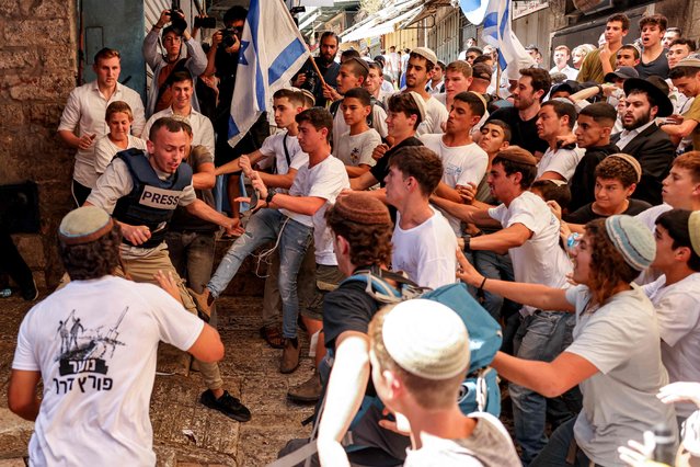 Israeli right-wing activists scuffle with Palestinian freelance journalist Saif Kwasmi on June 5, 2024 during the so-called Jerusalem Day flag march which commemorates the Israeli army's capture in the 1967 Arab-Israeli war of the city's eastern sector home to the Al-Aqsa mosque compound, Islam's third holiest site, which Jews call the Temple Mount. (Photo by Hazem Bader/AFP Photo)