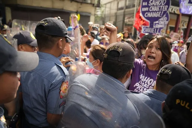 A protester shouts at police as they are temporarily blocked while trying to march near the Malacanang presidential palace in Manila, Philippines as they mark International Women's Day on Wednesday, March 8, 2023. (Photo by Aaron Favila/AP Photo)