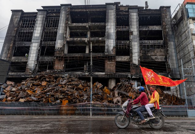 Nepalese Hindu devotees take part in a Durga religious rally as they pass in front of the Bhat-Bhateni supermarket, which was set ablaze during a violent protest on 09 September, in Kathmandu, Nepal, 03 October 2025. During Dashain, Nepalese worship Durga, the mother goddess of power and prosperity. (Photo by Narendra Shrestha/EPA)