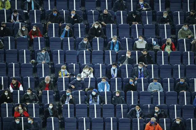 Spectators wearing face masks to protect against coronavirus watch the Champions League group F soccer match between Zenit St.Petersburg and Borussia Dortmund at the Saint Petersburg stadium in St. Petersburg, Russia, Tuesday, December 8, 2020. (Photo by Dmitri Lovetsky/AP Photo)