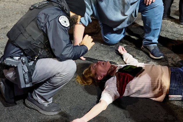 A police medic tends to a woman, who required medical attention, after federal officers pushed her down, in Portland, Oregon, U.S., October 27, 2025. (Photo by John Rudoff/Reuters)