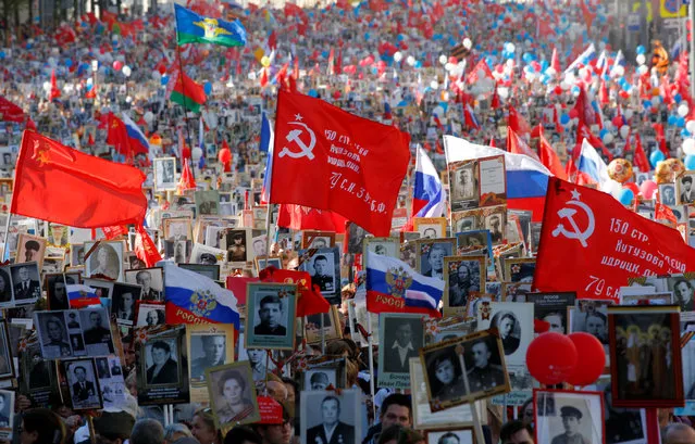 People hold flags and pictures of World War Two soldiers as they take part in the Immortal Regiment march in Moscow, Russia on May 09, 2018. (Photo by Sergei Karpukhin/Reuters)