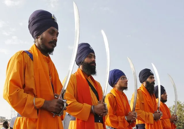 Sikhs dressed as "Panj Pyaare", or the five beloved of Sikh Gurus, hold swords as they take part in a religious procession in Ahmedabad, India, November 21, 2015. The procession is held annually in the city ahead of the birth anniversary of Guru Nanak Dev, the founder of the Sikh faith, which will be celebrated across the country on November 25. (Photo by Amit Dave/Reuters)