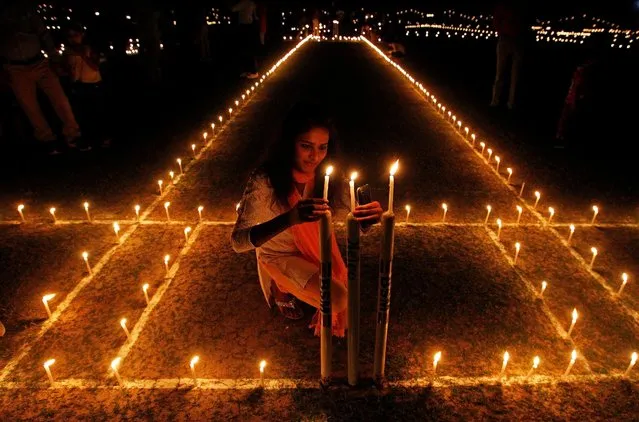 A girl lights candles inside a cricket stadium on the eve of Diwali, the Hindu festival of lights, in Allahabad, India, October 29, 2016. (Photo by Jitendra Prakash/Reuters)