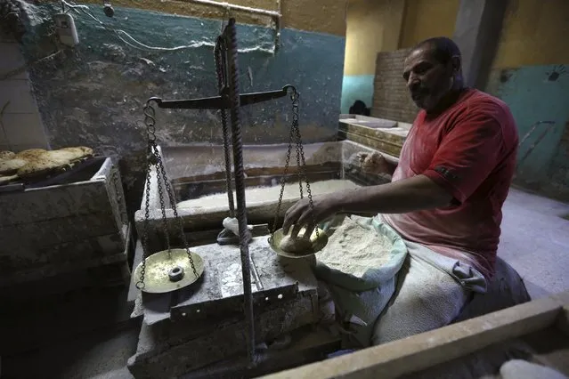 A worker weighs dough to be baked into bread at a bakery in Cairo, January 8, 2015. (Photo by Mohamed Abd El Ghany/Reuters)