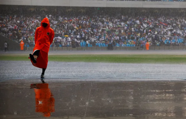 A security guard awaits the start of the closing ceremony of the Southeast Asian Games during a downpour in Phnom Penh, Cambodia on May 17, 2023. (Photo by Kim Kyung-Hoon/Reuters)