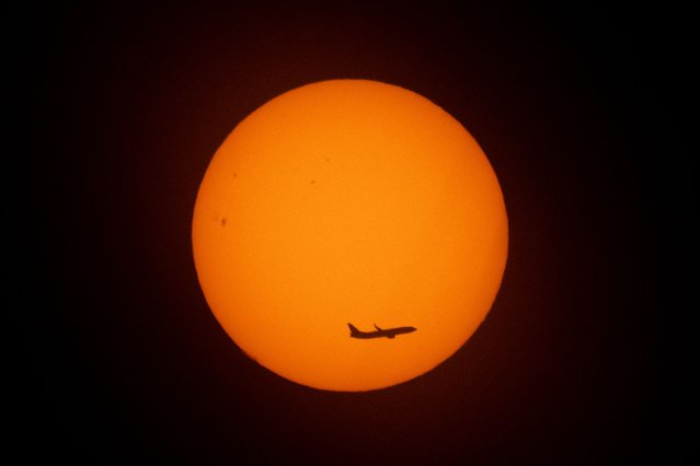 An aircraft flies at sunrise on November 13, 2025 in Buenos Aires. (Photo by Luis Robayo/AFP Photo)