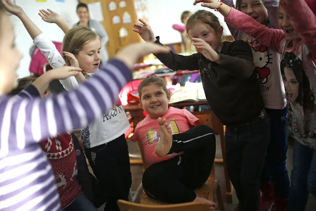 Ramela Meseljevic, a 7 year-old girl born without both of her hands and one of her legs shorter than the other, plays with her friends during a break in the her school in Begov Han, Bosnia and Herzegovina December 2, 2015. (Photo by Dado Ruvic/Reuters)