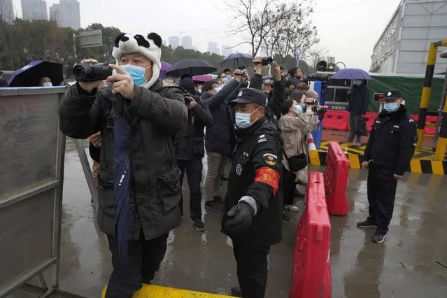 Security personnel block journalists after the World Health Organization team arrive at the Baishazhou wholesale market on the third day of field visit in Wuhan in central China's Hubei province on Sunday, January 31, 2021. WHO says the team plans to visit hospitals, markets and laboratories in a politically charged mission as China seeks to avoid blame for alleged early missteps. A single visit by scientists is unlikely to confirm the virus’s origins. (Photo by Ng Han Guan/AP Photo)