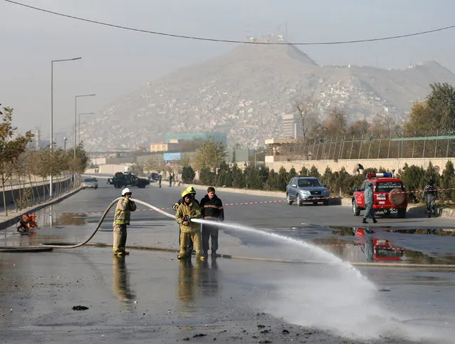 Afghan firefighters wash the road at the site of a suicide bombing in Kabul, Afghanistan, November 16, 2016. (Photo by Mohammad Ismail/Reuters)