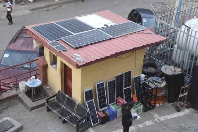 A man stands outside a shop with solar panels for sale in Abuja, Nigeria, Saturday June 17, 2023. Nigeria's removal of a subsidy that helped reduce the price of gasoline has increased costs for people already struggling with high inflation. But it also potentially accelerates progress toward reducing emissions in Africa's largest economy. (Photo by Olamikan Gbemiga/AP Photo)