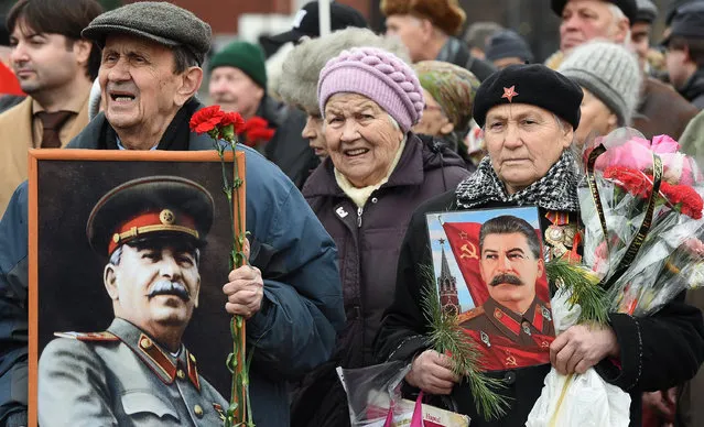 Russian Communist party supporters hold portraits of Soviet dictator Joseph Stalin as they take part in a ceremony to mark the 136th anniversary of his birth at Red Square in Moscow on December 21, 2015. (Photo by Vasily Maximov/AFP Photo)