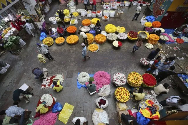 Flower vendors wait for buyers at a wholesale market in Bengaluru, India, Thursday, September 24, 2020. The nation of 1.3 billion people is expected to become the COVID-19 pandemic's worst-hit country within weeks, surpassing the United States. (Photo by Aijaz Rahi/AP Photo)