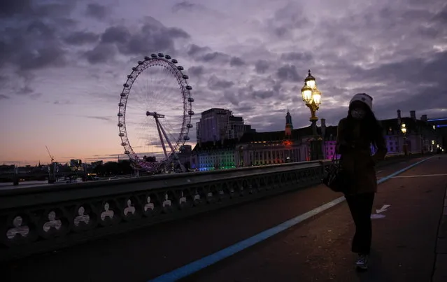 A person walks across the Westminster Bridge before sunrise, amid the coronavirus disease (COVID-19) outbreak, in London, Britain on October 16, 2020. (Photo by John Sibley/Reuters)