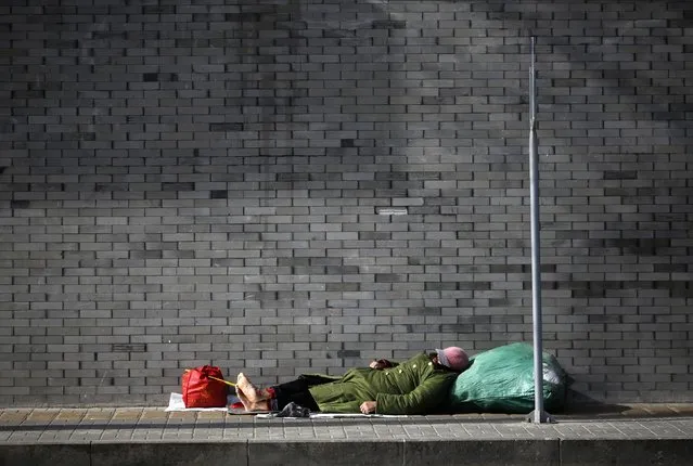 A man takes a nap on a street in Beijing February 6, 2015. (Photo by Kim Kyung-Hoon/Reuters)