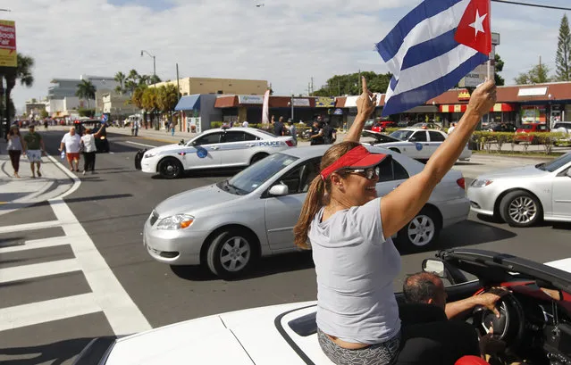 Pedestrians and vehicles are seen at the end of the closed  street near the iconic Cuban restaurant “Versailles” Saturday November 26, 2016 in the Miami neighborhood of Little Havana react the day after Cuban President Raul Castro announced  his brother and former Cuban President, Fidel Castro's death in Cuba the night before. (Photo by Andrew Innerarity)