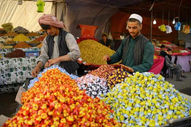 In this photograph taken on June 9, 2018 an Afghan dry fruits and sweets vendor arranges his products while waiting for costumers ahead of the Eid al-Fitr festival, which marks the end of Islamic holy month of Ramadan, at a roadside stall in Herat province. (Photo by Hoshang Hashimi/AFP Photo)