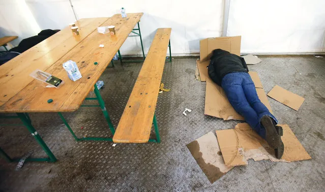 A migrant rests on cardboards at the the Berlin Office of Health and Social Affairs (LAGESO), in Berlin, Germany, January 5, 2016. (Photo by Hannibal Hanschke/Reuters)