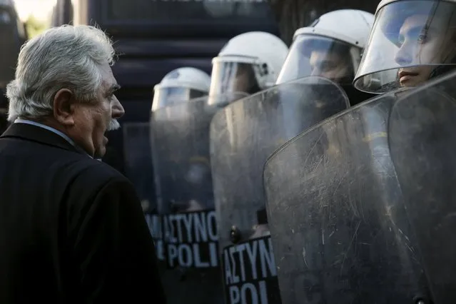 Greek Communist Party (KKE) lawmaker Christos Katsotis (L) talks to a police officer as he stands in front of a police cordon during a demonstration against a set of government's planned pension reforms in Athens, Greece, January 8, 2016. (Photo by Alkis Konstantinidis/Reuters)