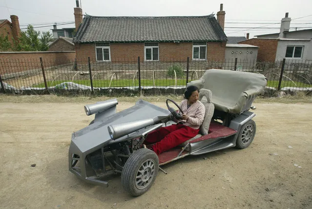 Zhang Jinduo's wife tries on a self-made racing car on the outskirts of Shenyang, Liaoning province May 10, 2008. Zhang, the 53-year-old local farmer made the racing car with the help of his son who is a car mechanic. The car is equipped with a rear-mounted motorcycle engine and can achieve 60-80 km per hour, according to local media. (Photo by Reuters/Stringer)