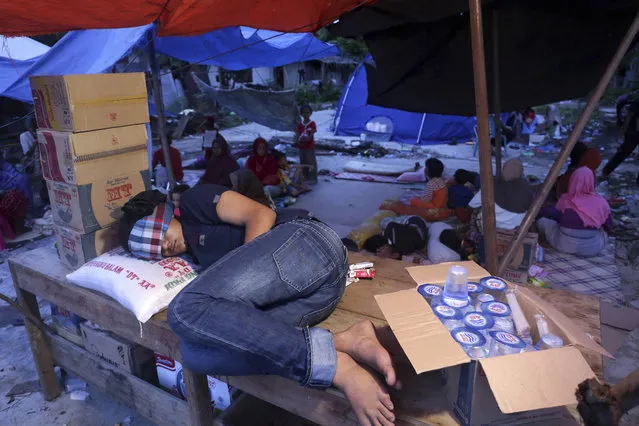 An earthquake survivor sleeps on a table at a temporary shelter in Pidie Jaya, Aceh province, Indonesia, Friday, December 9, 2016. (Photo by Heri Juanda/AP Photo)