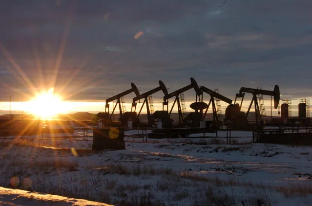 This January 14, 2015 file photo shows oil pump jacks in McKenzie County in western North Dakota. Dozens of European lawmakers, business executives and union leader called Tuesday for the United States to cut its greenhouse gas emissions by 50% in the coming decade compared with 2005 levels. (Photo by Matthew Brown/AP Photo/File)