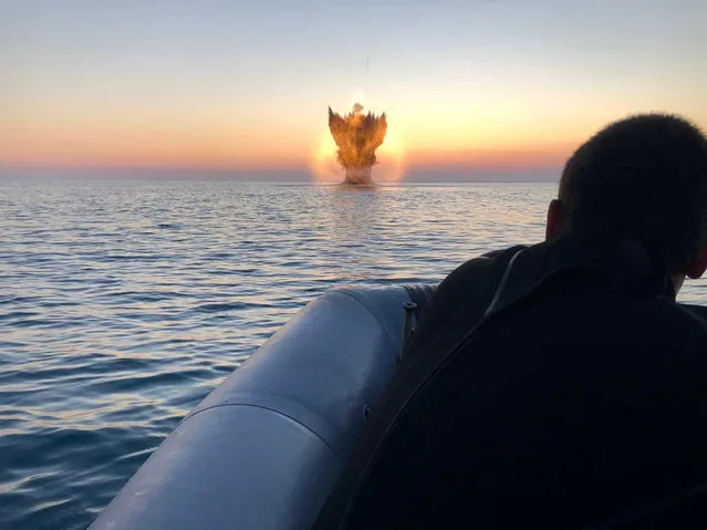 Bulgarian navy personnel destroy a naval mine in the Black Sea, Bulgaria, in this handout image released on July 1, 2022. (Photo by Bulgarian Ministry of Defence/Handout via Reuters)
