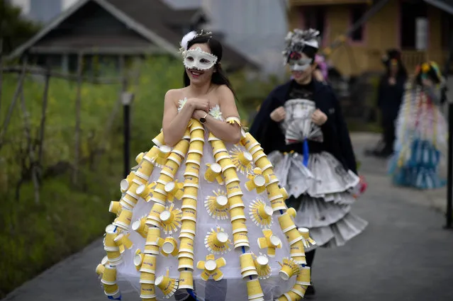 In this Thursday, March 19, 2015 photo, workers in outfits made from scrap material parade through a farm on the rooftop of a door manufacturer in Chongqing municipality in southwest China. Employees of the company designed and modeled their garments as part of an environmental sustainability-themed fashion show, which was held by the firm as a morale-booster for employees. (Photo by AP Photo)