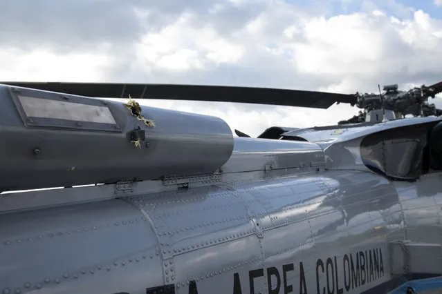 In this photo released by Colombia's Presidency, bullet holes are seen on the fuselage of a Colombian Air Force helicopter that were fired while Colombia's President Ivan Duque and members of his cabinet were traveling on the helicopter, at the airport in Cucuta, Colombia, Friday, June 25, 2021. Duque said the aircraft was attacked while traveling on it with his ministers of defense and interior in the Catatumbo region, on the northeastern border with Venezuela. (Photo by Cesar Carrion/Presidency of Colombia via AP Photo)