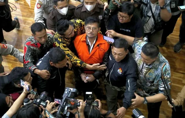 Former Indonesian Agriculture Minister Syahrul Yasin Limpo (C) is escorted by the Corruption Eradication Commission officers after a press conference following his arrest by the Corruption Eradication Commission in Jakarta, Indonesia, 13 October 2023. The anti-graft commission has arrested Limpo, who has just resigned from his position, accusing the former minister of bribery. (Photo by Bagus Indahono/EPA)