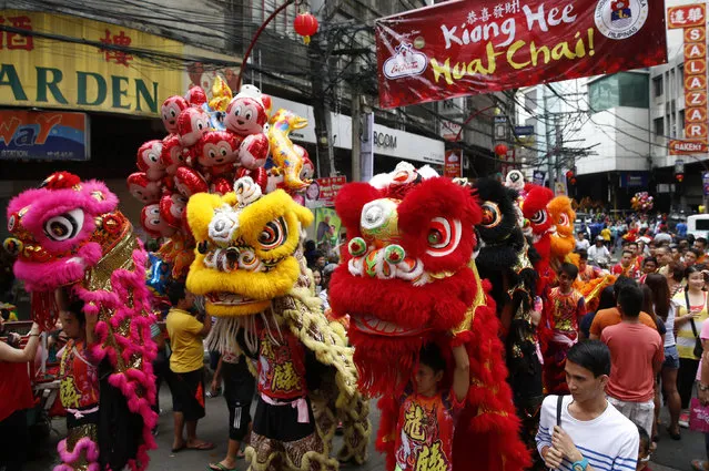 Lion dancers carry their costumes on the Eve of the Chinese New Year celebrations in Manila's Chinatown, Philippines February 7, 2016. (Photo by Erik De Castro/Reuters)