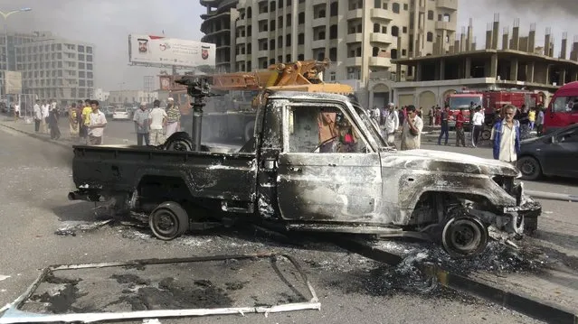 People look at a burnt-out police patrol vehicle after clashes in Yemen's southern port city of Aden February 9, 2016. The recapture of Aden by Gulf Arab coalition troops last summer has failed to provide any respite from Yemen's civil war, with residents facing a wave of bomb and gun attacks that is crippling efforts to stabilize the city. (Photo by Reuters/Stringer)