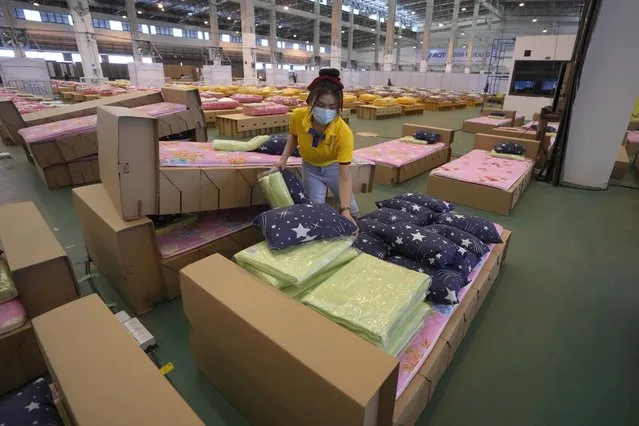A worker prepares a 1,800-bed field hospital set up inside a cargo building in Don Mueang International Airport in Bangkok, Thailand, Thursday, July 29, 2021. Health authorities raced on Thursday to set up yet another large field hospital in Thailand's capital as the country recorded a new high in COVID-19 cases and deaths. The hospital, one of many already in use, was being set up at one of Bangkok's two international airports after the capital ran out of hospital beds for thousands of infected residents. (Photo by Sakchai Lalit/AP Photo)