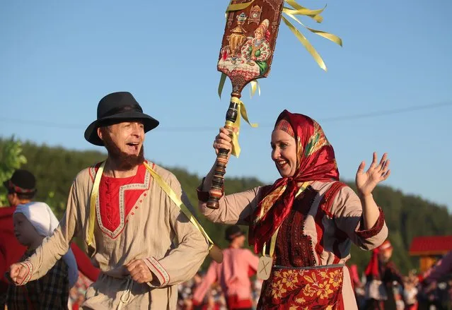 People wearing folk costumes take part in celebrations of the Pitrau feast by the Kryashens ethnic group marking the Day of Saints Peter and Paul (which is celebrated on July 12), at the Tyrlau valley in the village of Zyuri, Mamadyshsky District in Republic of Tatarstan, Russia on July 17, 2021. Kryashens are an Orthodox Christian ethnic group living in Russia's Republic of Tatarstan. (Photo by Yegor Aleyev/TASS)