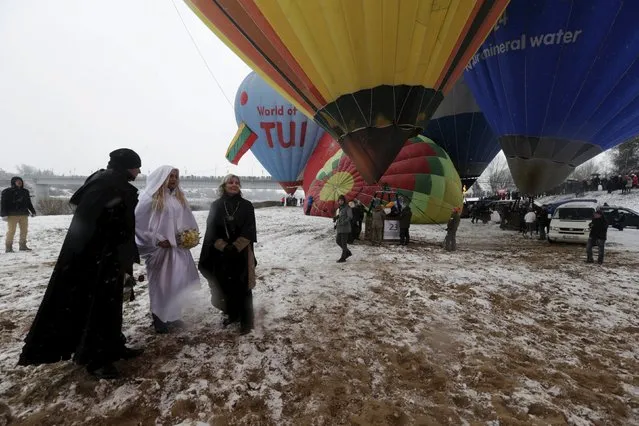 A marriage official and a couple wait to get onto a hot air balloon during the “Love Cup 2016” festival on Valentine's Day in Jekabpils, Latvia, February 14, 2016. (Photo by Ints Kalnins/Reuters)