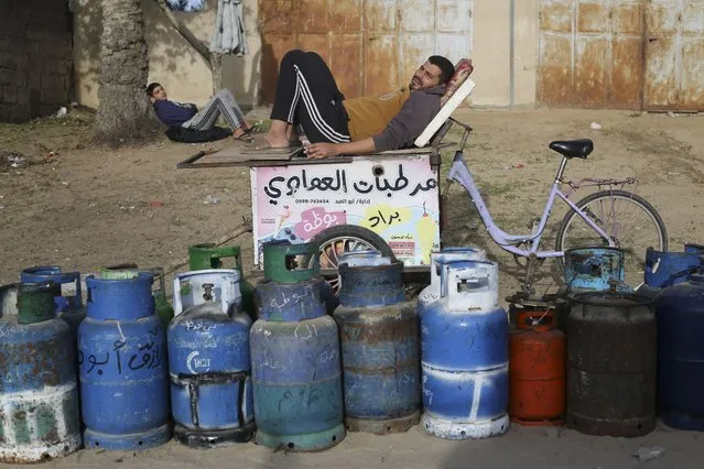 Palestinians line up for cooking gas during the second day of the temporary ceasefire between Hamas and Israel in Rafah, Gaza Strip, Saturday, November 25, 2023. (Photo by Hatem Ali/AP Photo)