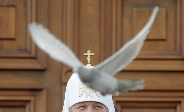 Russian Orthodox Patriarch Kirill releases a white dove to mark the Annunciation Day in the Kremlin in Moscow, Russia, April 7, 2015. Annunciation is one of twelve main holidays of Christianity and celebrates the Annunciation of the Blessed Virgin Maria by Archangel Gabriel (Gavriil) that she will give birth to Jesus Christ. (Photo by Maxim Shipenkov/EPA)